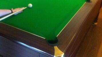 Una mesa de billar con bolas y taco.