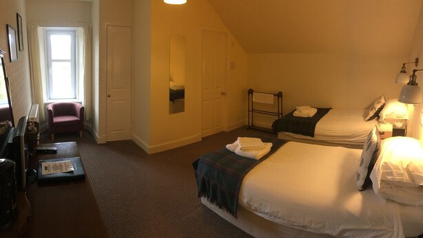 A hotel room with two beds, a desk with a chair, a wardrobe, and a window. - Loch Shiel Hotel (Acharacle)