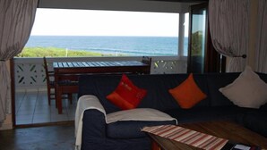 Ein Zimmer mit Meerblick, eine Couch mit Kissen, ein Tisch und ein Schild mit der Aufschrift Rauchverbot.