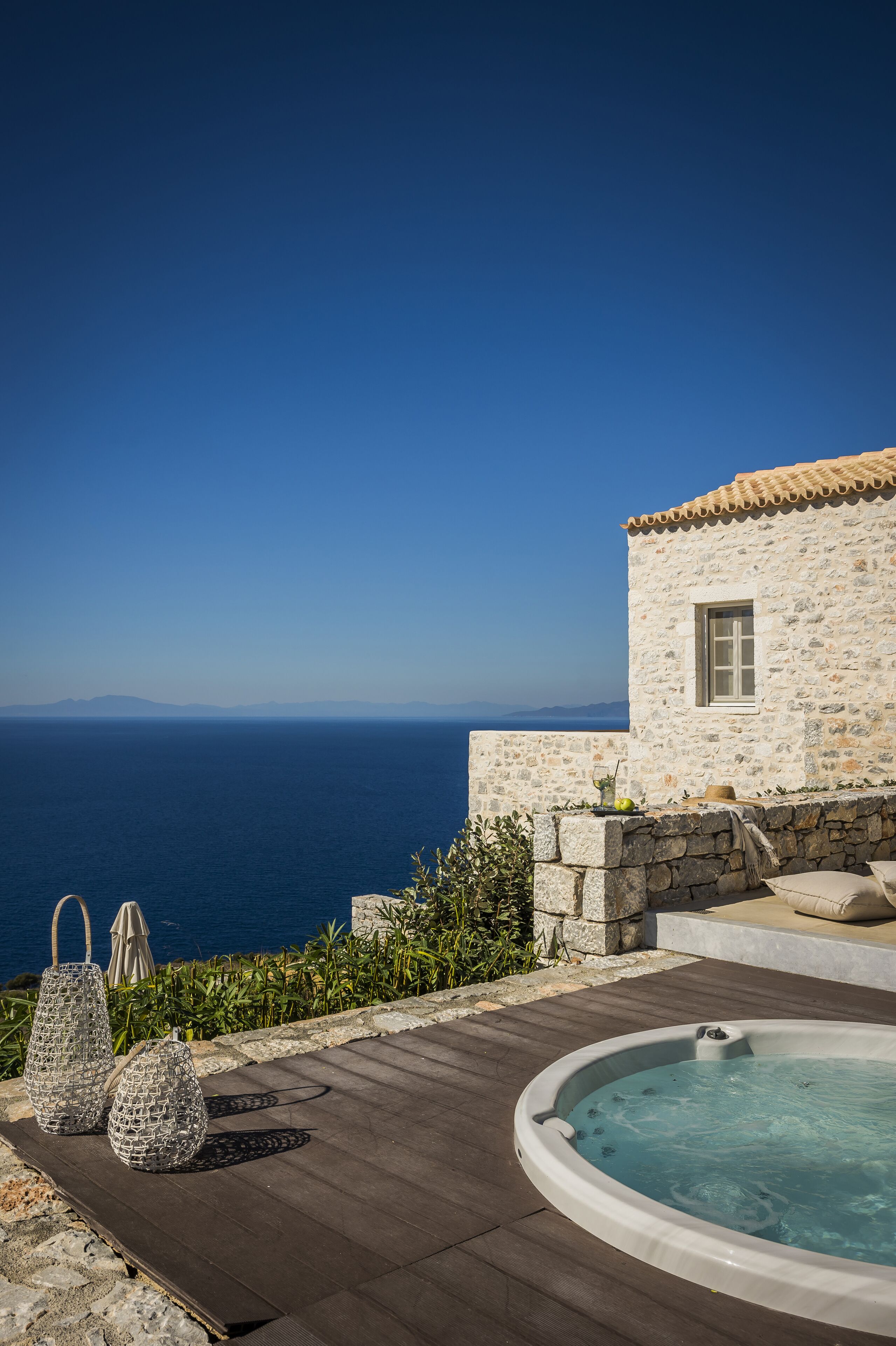 Un edificio de piedra con piscina y zona de estar al aire libre.