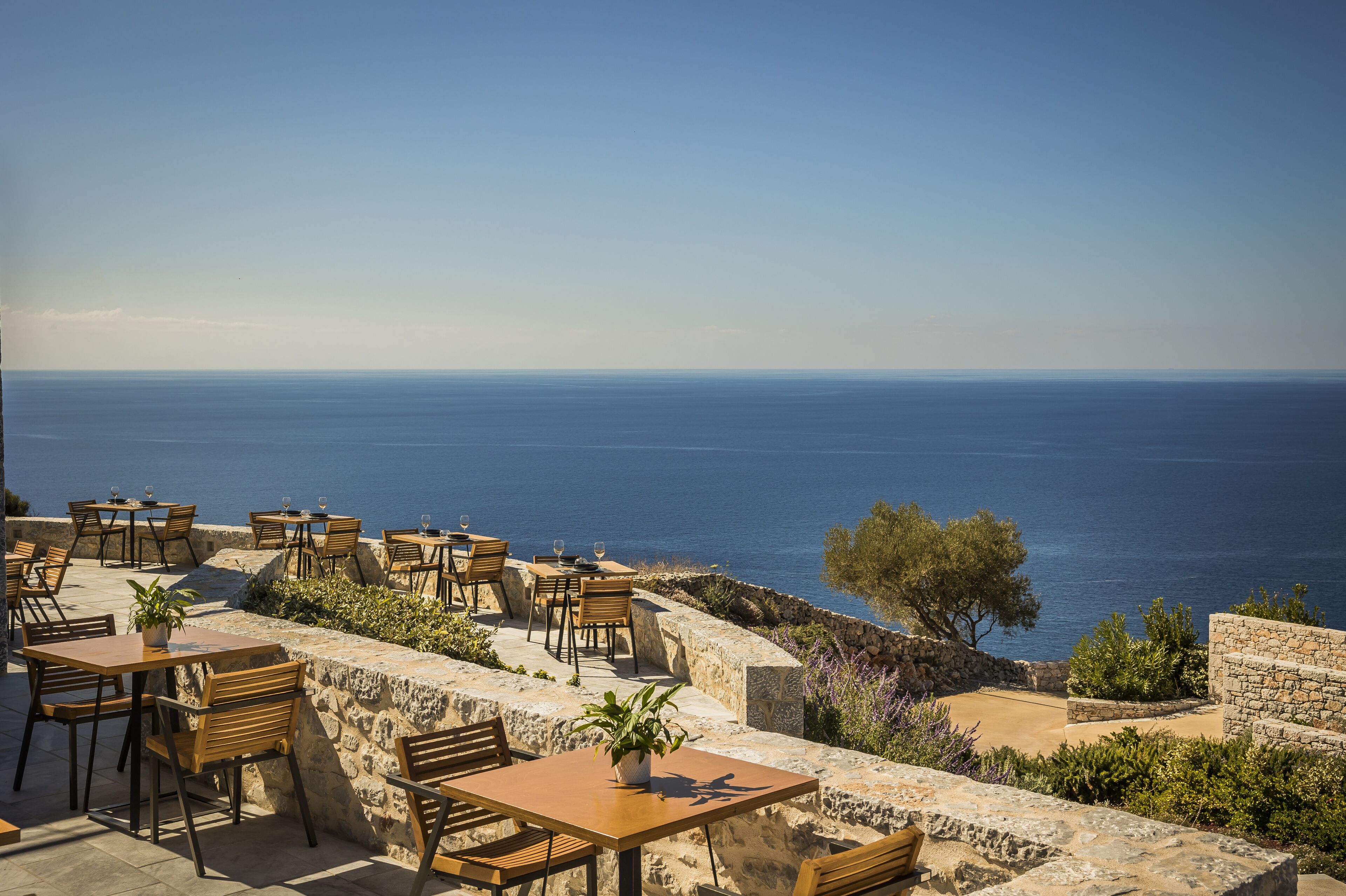 A seaside restaurant with outdoor seating overlooking the ocean.