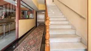 A hotel corridor with a carpeted floor, a wooden handrail, and a staircase. - Casa Marín (Sanxenxo)