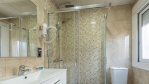 A modern bathroom with a glass-enclosed shower, a white sink, and a toilet. - Casa Marín (Sanxenxo)