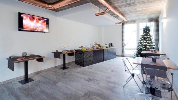 A modern living room with a flat-screen TV, a coffee station, and a Christmas tree. - Agriturismo Camisi (Cambiago)