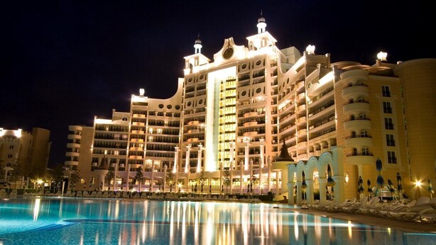 A large hotel with multiple balconies and a swimming pool in the foreground. - Sunset Resort (Pomorie)
