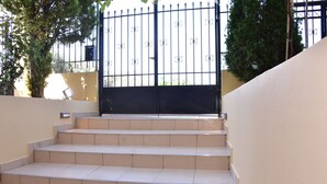A set of beige tiled steps leading up to a black metal gate. - Keratea Apartment Athens Airport (Lavreotiki)