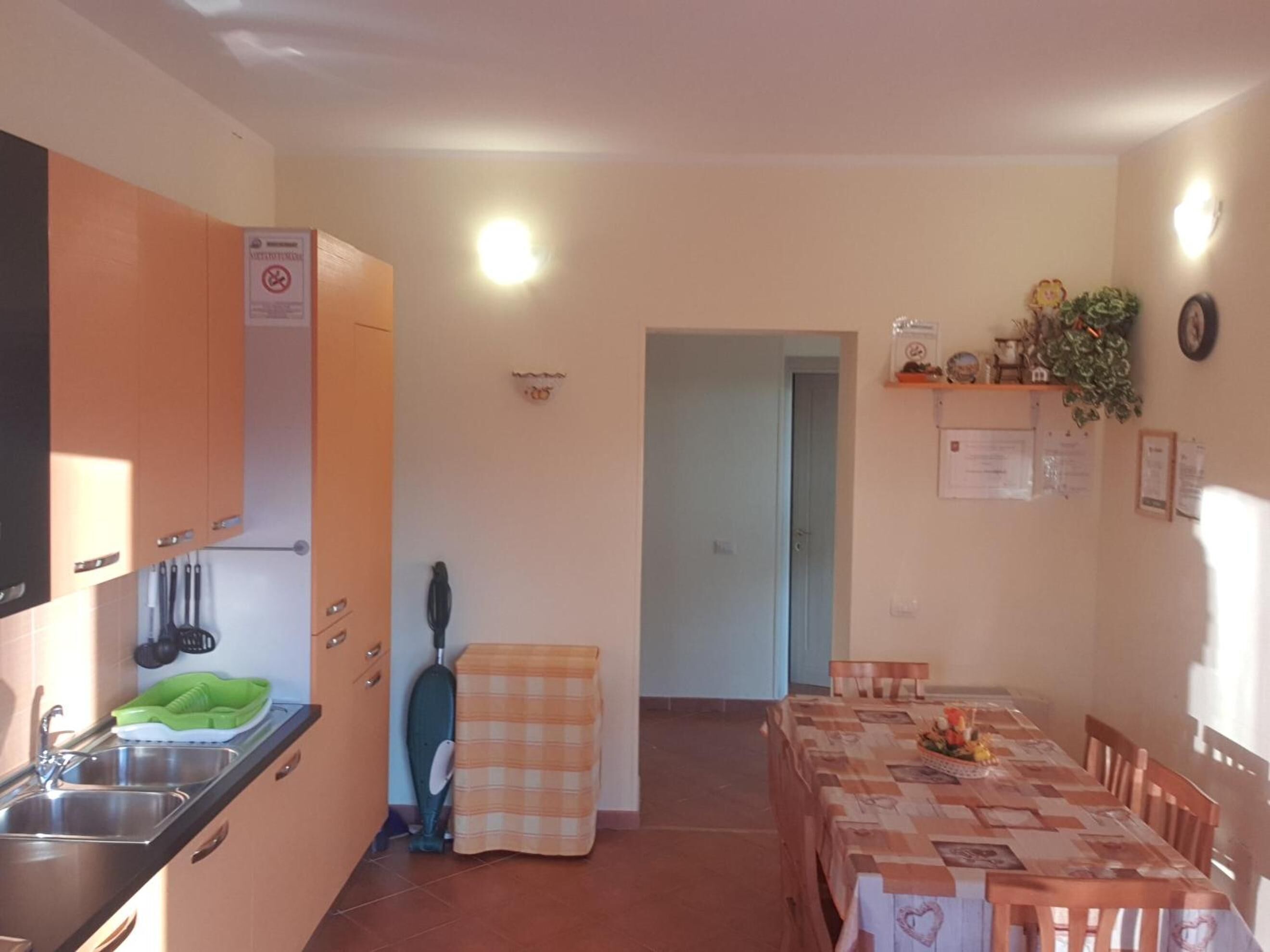 A compact kitchen with a sink, cabinets, and a dining area with a table and chairs.