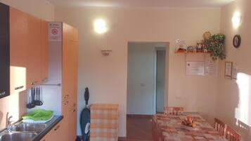 A compact kitchen with a sink, cabinets, and a dining area with a table and chairs.