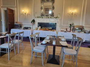 A dining area with tables set for breakfast, a fireplace, and a mirror above it. - Leixlip Manor Hotel (Leixlip)