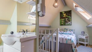 A bedroom with a skylight, a bed, a bedside table, and a white dresser. - Charming house in the valley for 2, nature and tranquility (Beauficel)