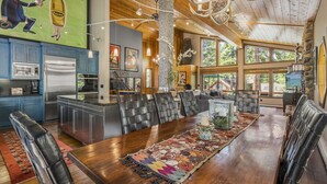 A spacious dining area with a long wooden table, black leather chairs, and a colorful rug. - Artist’s Haven – Stylish Dollar Point Home with Hot Tub Near Skylandia Beach (Tahoe City)