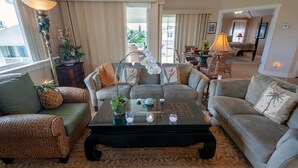 A spacious living room with a large coffee table, two sofas, and a dining area with a table and chairs. - 3br Plantation at Princeville! AC, fitness center, hot tub,, garage, more! (Princeville)