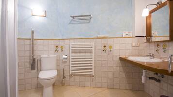 A bathroom with a toilet, a sink, a towel rack, and a mirror.