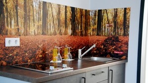 A kitchen with a stainless steel countertop, two sinks, and a cabinet with drawers. - TaT Hotel (Rheine)