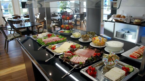 A buffet with various food items including meats, cheeses, and salads. - TaT Hotel (Rheine)