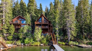 Une cabane avec un quai et des chaises, entourée d’une forêt dense.
