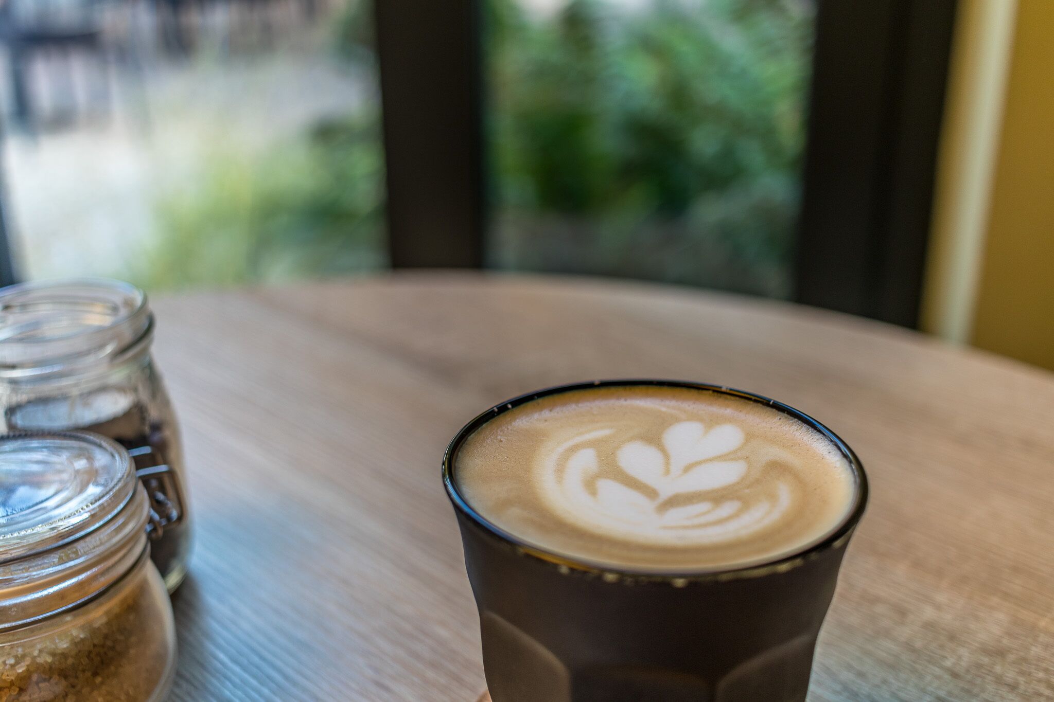 Una taza de café con arte de latte sobre una mesa de madera.