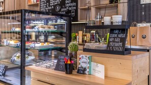 Une vitrine de boulangerie présentant diverses pâtisseries et, au fond, un panneau affichant le menu.