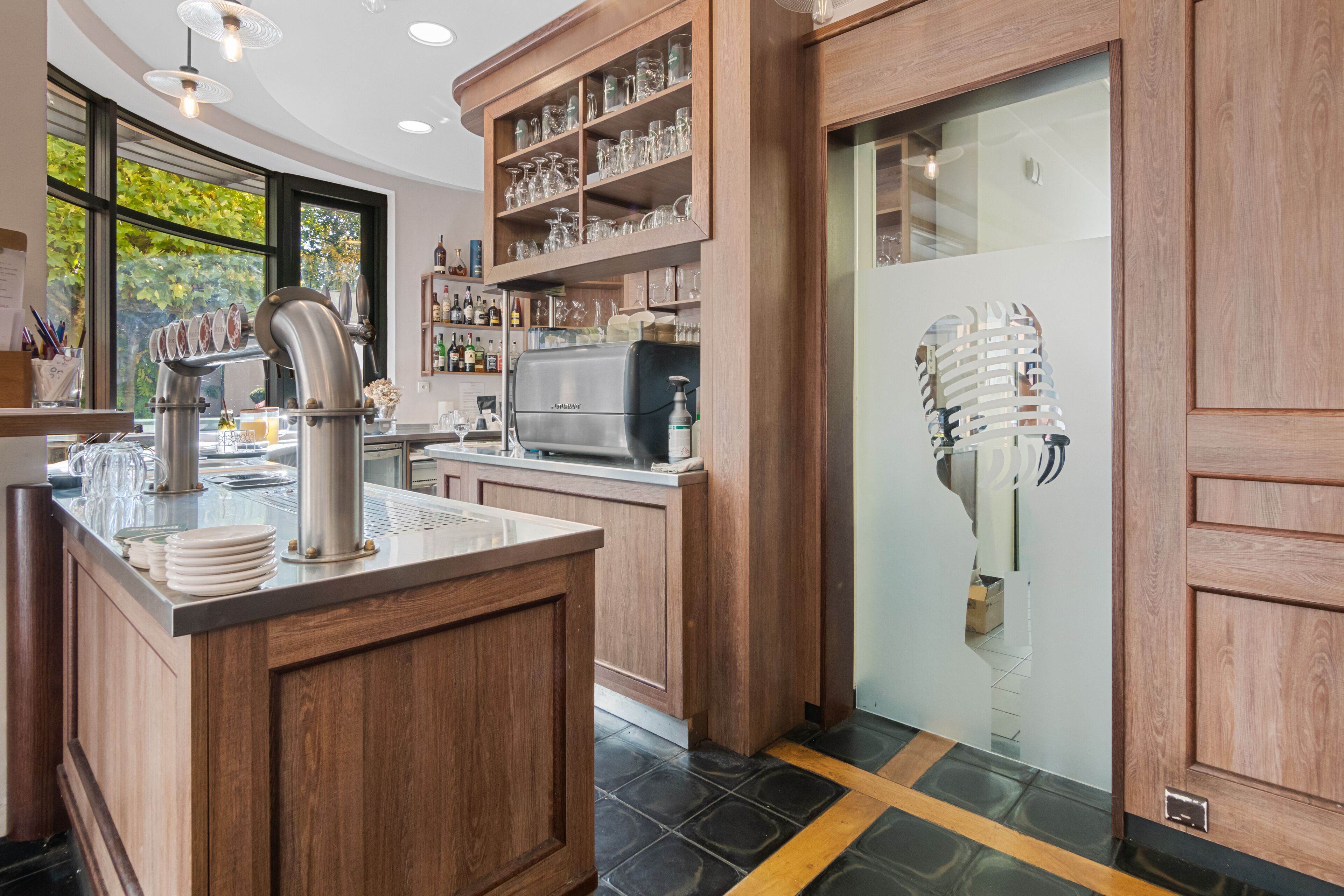 A modern kitchen with wooden cabinetry, a stainless steel sink, and a built-in wine rack.
