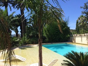 Una piscina al aire libre de temporada, sombrillas