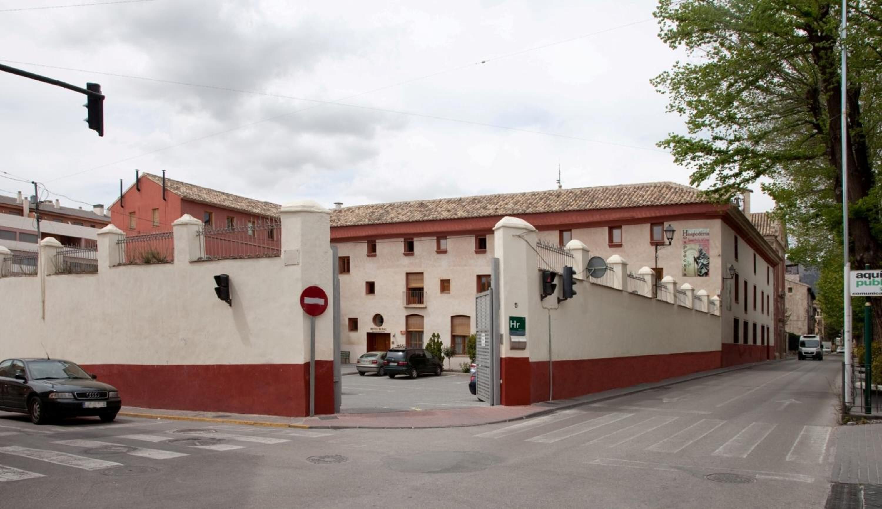 Ein Gebäude mit roter und weißer Fassade, einem Verbotsschild und einer Straße mit Autos.