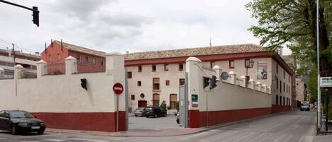 Ein Gebäude mit roter und weißer Fassade, einem Verbotsschild und einer Straße mit Autos.