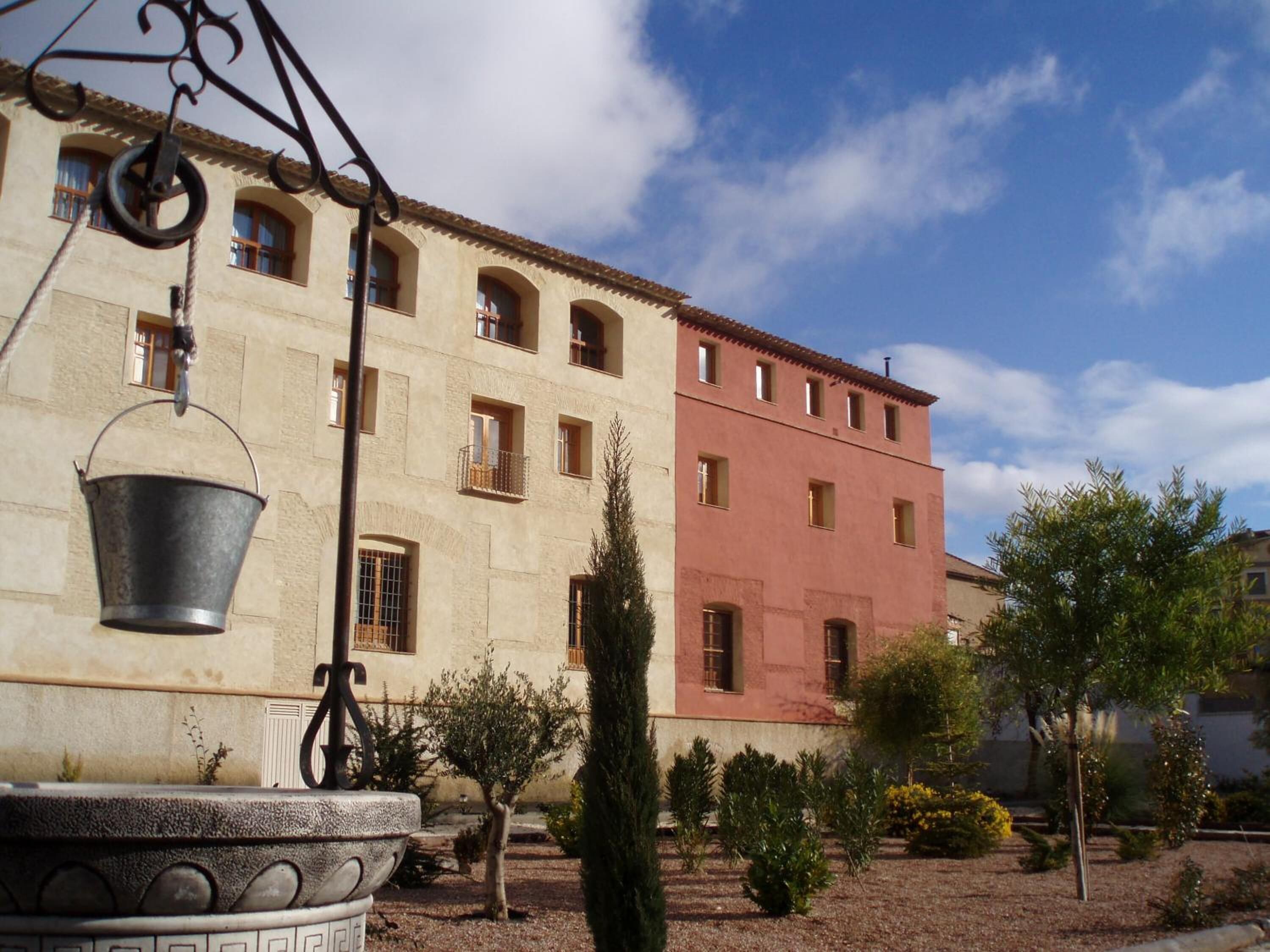 A building with a courtyard, including a metal bucket and a decorative planter.