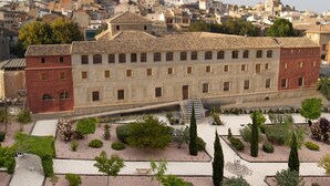 A historic building with a courtyard featuring neatly trimmed hedges and a central staircase. - Hospedería Nuestra Señora del Carmen (Caravaca de la Cruz)