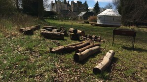 A rustic outdoor setting with a stone building and a yurt in the background. - Bamff Ecotourism (Blairgowrie)