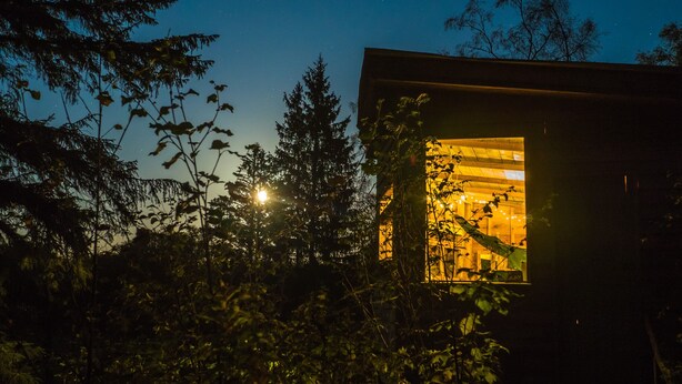 A small, modern building with a visible interior illuminated by warm lighting. - Bamff Ecotourism (Blairgowrie)