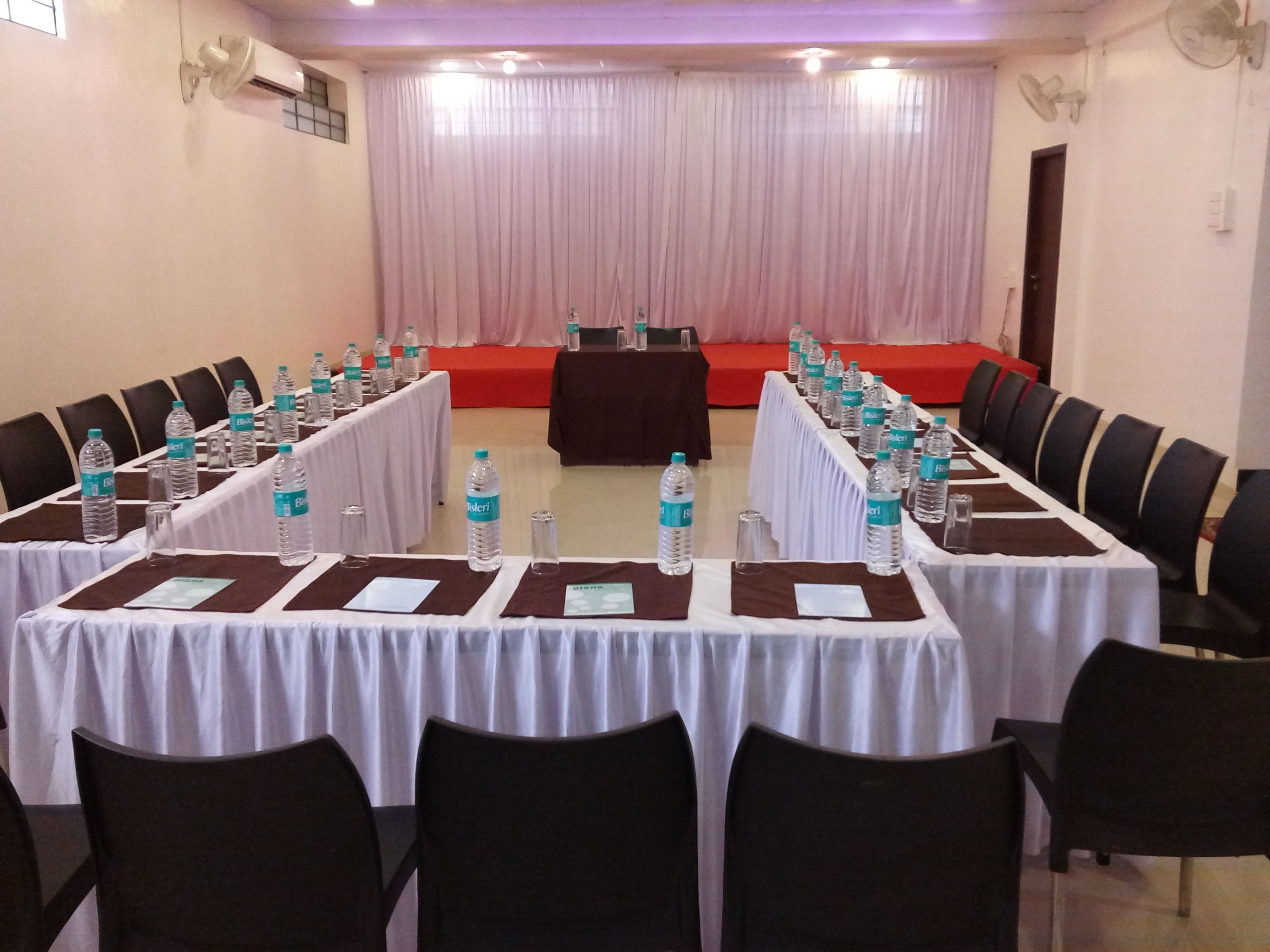 A conference room with a long table, chairs, water bottles, and name cards.