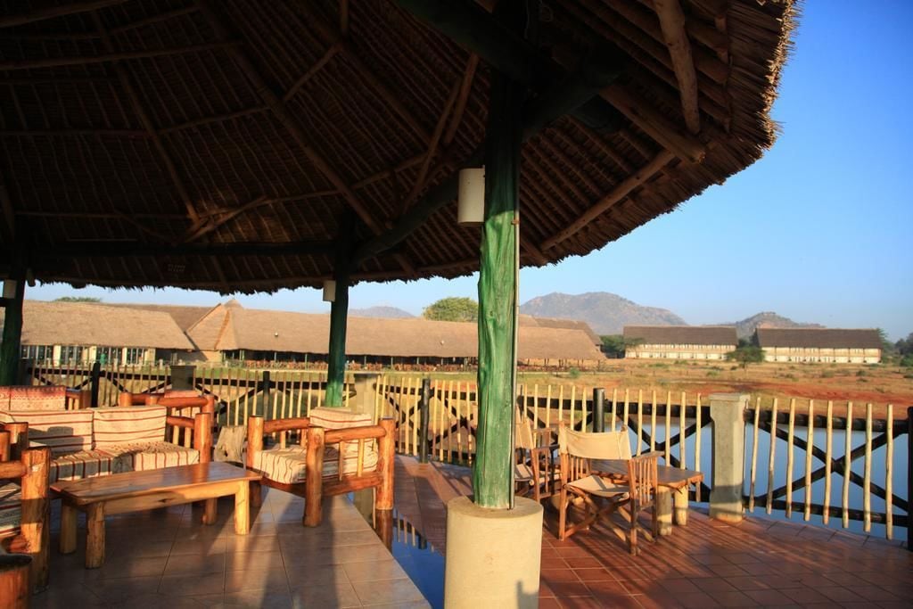 An outdoor seating area with wooden furniture and a thatched roof structure.
