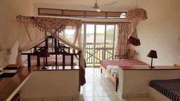 Una habitación con cama, escritorio, silla, ventana y puerta.