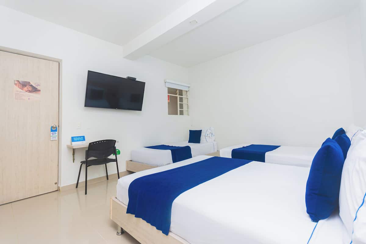 Hotelkamer met twee bedden, een aan de muur bevestigde televisie, een klein bureau met stoel en een raam met uitzicht.