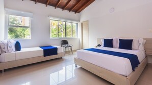 A modern hotel room with two beds, a wooden ceiling, large windows, and a view of greenery outside. - Hotel Suite Del Parque (Medellín)