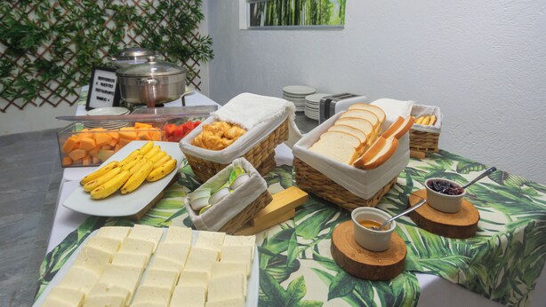 A buffet table with various food items including bread, cheese, and fruits. - Hotel Suite Del Parque (Medellín)