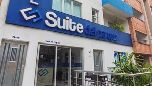 A hotel named "Suite de Parque" with a modern design, featuring a blue and white facade, a visible entrance, and outdoor seating area. - Hotel Suite Del Parque (Medellín)