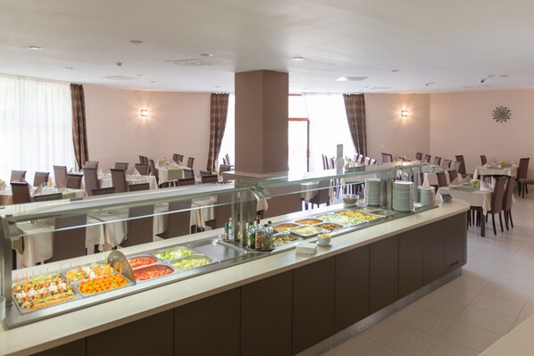 A buffet area with multiple food stations and dining tables.