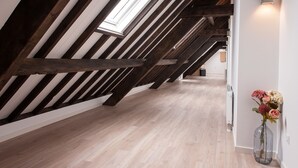 An attic room with exposed wooden beams, a skylight, and a wooden floor. - Ruyge Weyde Logies (Oudewater)