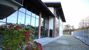 A modern building with large glass windows and brick pillars. - Il Vecchio Mulino di Bairo (Bairo)