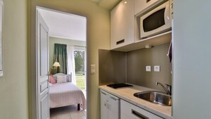 A compact kitchen with a built-in microwave, a sink, and a dishwasher. - Maison d'Hôtes de la Milane (Cabries)