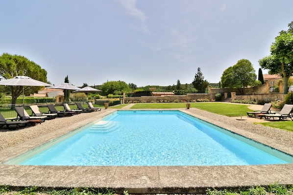 Una piscina al aire libre de temporada, tumbonas