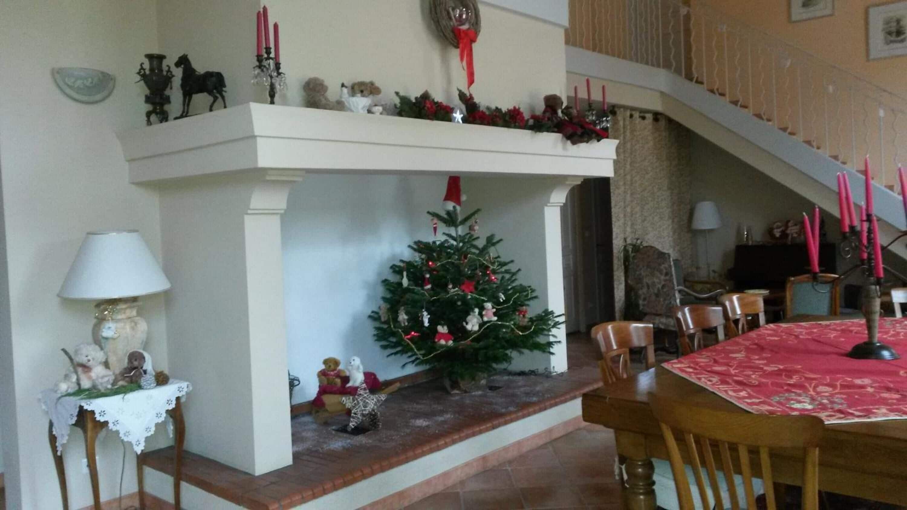 Een eetgedeelte met een open haard, een kerstboom en een trap.