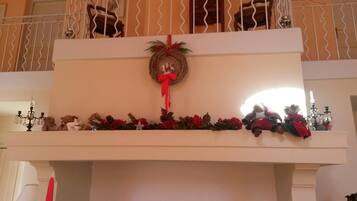 A decorated balcony with a wreath, Christmas decorations, and a chandelier.