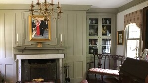 A traditional room with a fireplace, a chandelier, a dining table, and a chair. - Governor's Bed and Breakfast (Milton)