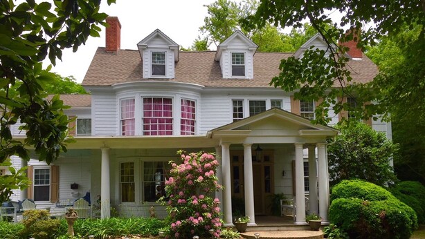 A two-story house with a front porch and a small portico. - Governor's Bed and Breakfast (Milton)