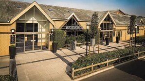 A hotel with a modern architectural design, featuring large windows and a prominent entrance. - Waterside Holiday Park & Spa (Weymouth)