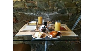 Una mesa con comida, un vaso de jugo y una taza de café.