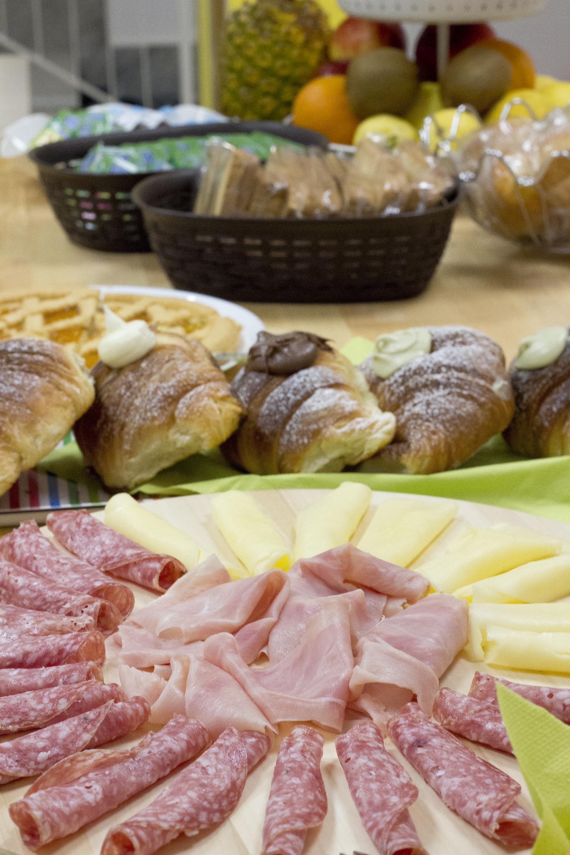 A variety of food items including pastries, meats, and cheeses arranged on a table.
