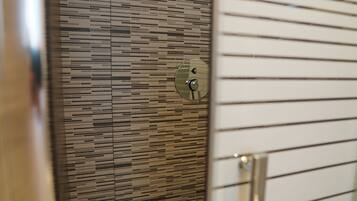 Une salle de bain moderne avec un mur carrelé et un robinet métallique.